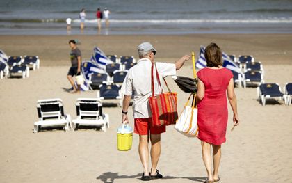 Strandgangers zoeken verkoeling op het strand van Zandvoort voor de tropische temperaturen. beeld ANP RAMON VAN FLYMEN