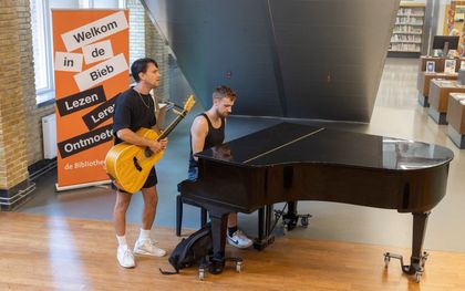 Vrienden Aron en Jimmy maken spontaan muziek in de hal van de bieb. beeld Erik Kottier