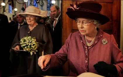 Koningin Elizabeth II en prins Philip brachten in 2007 een bezoek aan Nederland. Op de foto tekent ze het gastenboek van de Engelse Hervormde Kerk aan de Begijnhof in Amsterdam. Haar binding met de kerk is een van de rode draden door haar leven. beeld ANP, Robin Utrecht