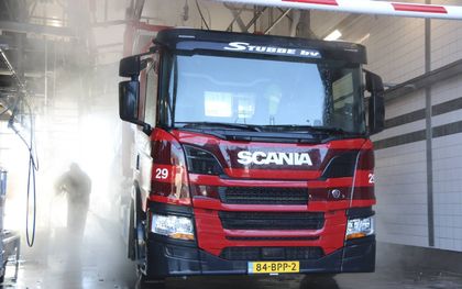Branko Compeer spuit zijn Scania P280 schoon in de wasstraat van Stubbe Logistiek. beeld Sjaak van de Groep