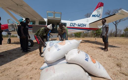 Een MAF-piloot levert zakken voedsel af. beeld MAF, Marijn Goud
