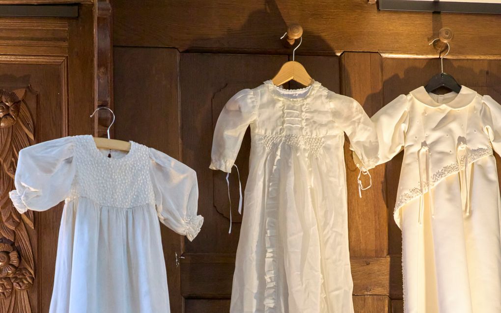 Een lange jurk, hangend aan een wand. 