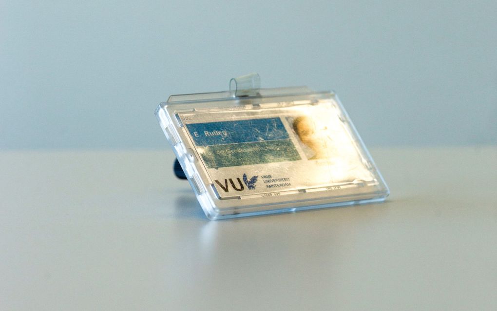Een pasje in een pasjeshouder. Op het pasje staat ”E. Rutten” en onderin een logo met daarin de letters VU en daarnaast: Vrije Universiteit Amsterdam. Er is vaag ook een pasfoto te zien