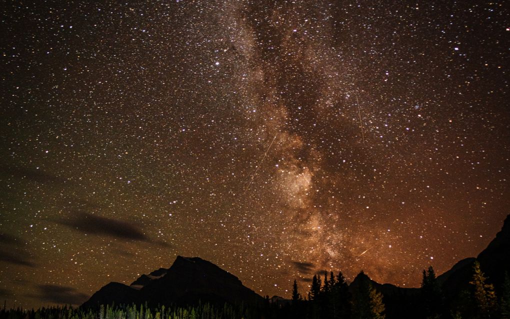 Duizenden kleine witte lichtjes in de lucht tonen de sterrenhemel bij nacht.