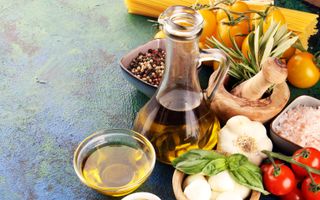 Schaaltjes met typische onderdelen van het mediterraan dieet: olijfolie, olijven, tomaten en knoflook. 