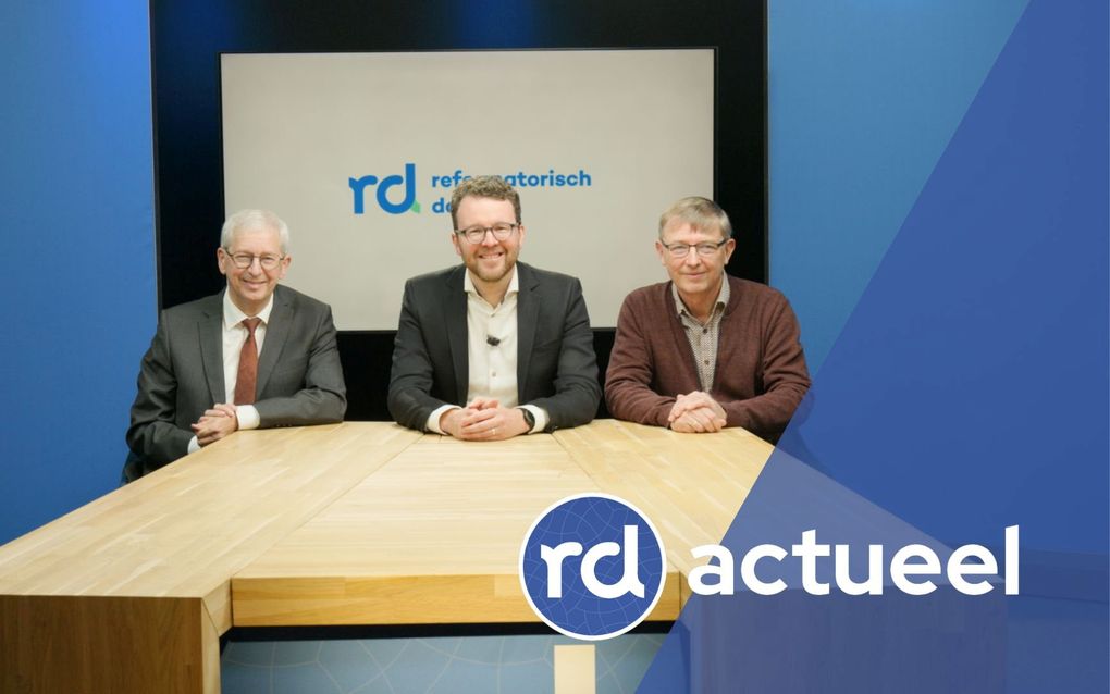 Drie mannen achter een tafel.