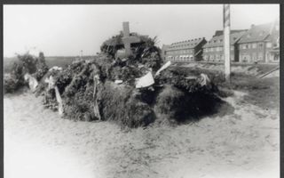 Een kruis te midden van hooibalen, opgericht als provisorisch monument.