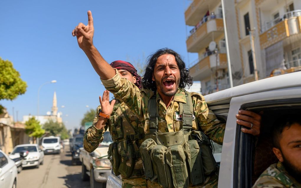 Syrische oppositiestrijders, gesteund door het Turkse leger, op weg naar de grens met Syrië. beeld AFP