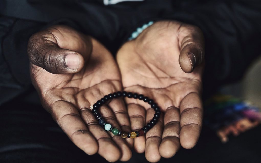 Voor John, gevlucht uit Sierra Leone, is een armband de enige tastbare herinnering die hij heeft aan zijn thuisland. beeld Michel Khoury