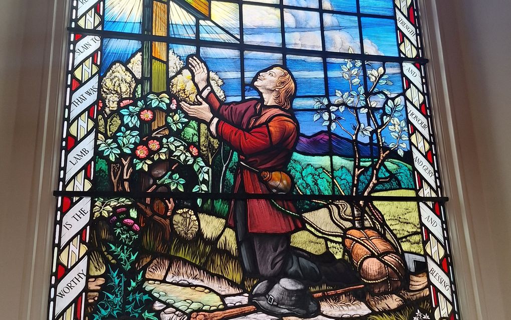 Christen verliest zijn zondepak aan de voet van het kruis: glas-in-loodraam in de Bunyan Meeting Church in Bedford. beeld Bastiaan van Soest