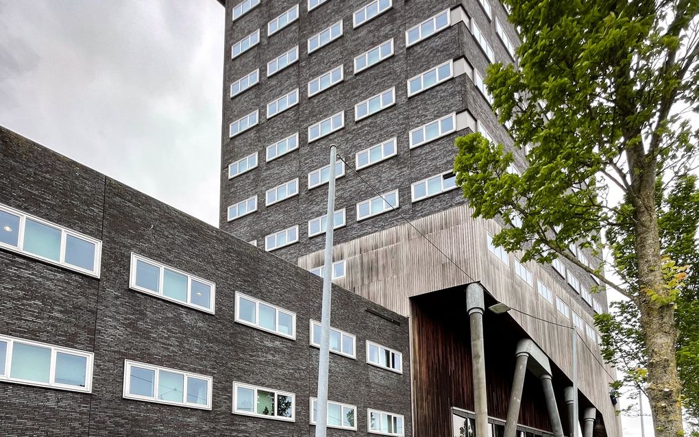 Groot politiebureau, met op de voorgrond een bord met ”Bezoekers. Cellencomplex. Goederenontvangst”.