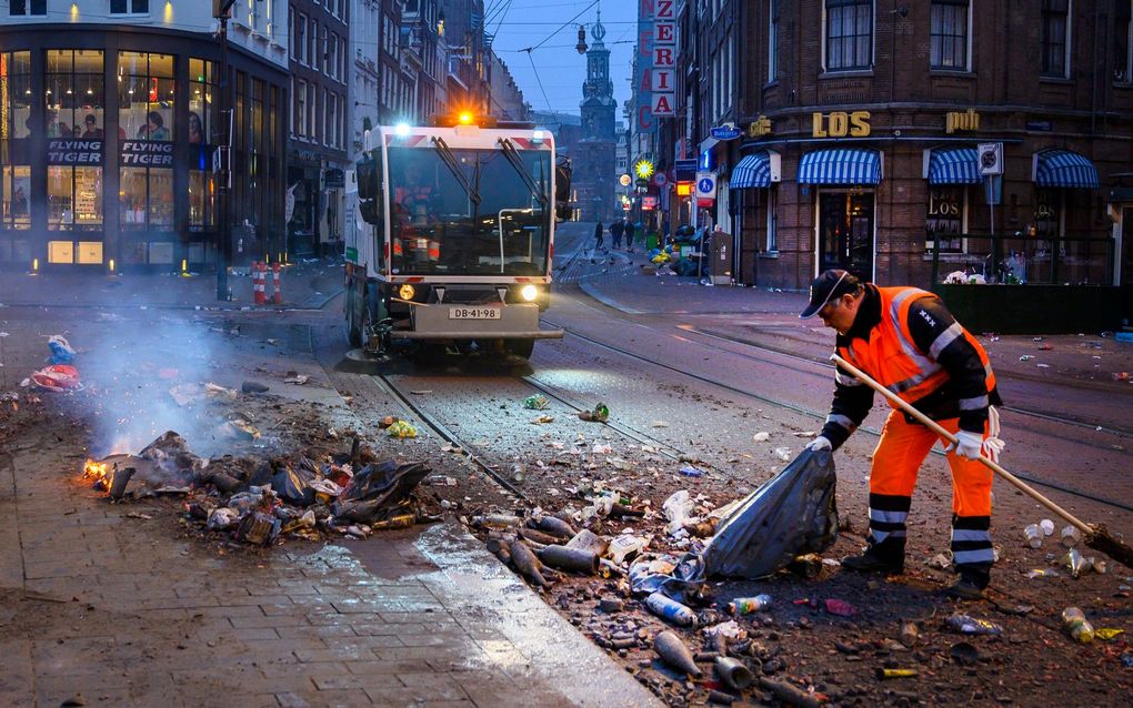 Medewerkers van de gemeente vegen op nieuwjaarsdag op het Rembrandtplein in Amsterdam de vuurwerkrommel op. beeld ANP