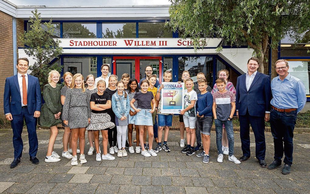 Wethouder André Flach (l.) uit Hendrik-Ido-Ambacht reikte donderdagmorgen de zogeheten Respect2025-award uit aan groep 8a van de Stadhouder Willem III-school. De klas ontvangt de award omdat deze het beste resultaat leverde bij het landelijke scholenproject Respect2025, dat door KlasseTaal –de onderwijstak van de Bond tegen vloeken– werd georganiseerd. beeld RD, Henk Visscher