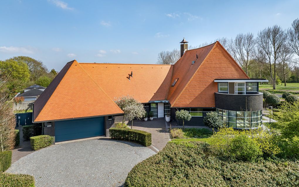 Vooraanzicht van een exclusieve woning met fraai aangelegde tuin