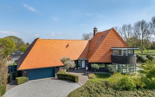 Vooraanzicht van een exclusieve woning met fraai aangelegde tuin
