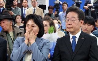 Oppositieleider Lee Jae-myung (r.) en zijn vrouw volgens gespannen de laatste uitslagen. beeld EPA, Yonhap