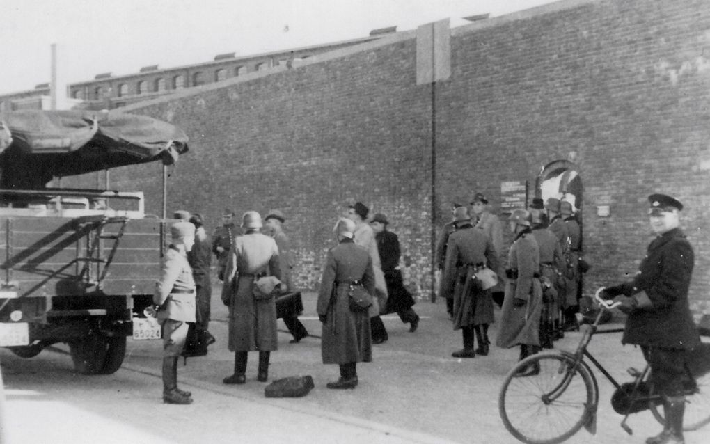 Vlaardingse verzetsstrijders verlaten het Oranjehotel in Scheveningen, op weg naar concentratiekamp Buchenwald in Duitsland. Andere gevangenen moesten door dit poortje richting de fusilladeplaats op de Waalsdorpervlakte. beeld NM Oranjehotel