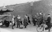 Vlaardingse verzetsstrijders verlaten het Oranjehotel in Scheveningen, op weg naar concentratiekamp Buchenwald in Duitsland. Andere gevangenen moesten door dit poortje richting de fusilladeplaats op de Waalsdorpervlakte. beeld NM Oranjehotel