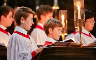 Jongens van het King’s College Choir Cambridge in wit met rode toga’s in kerkbanken