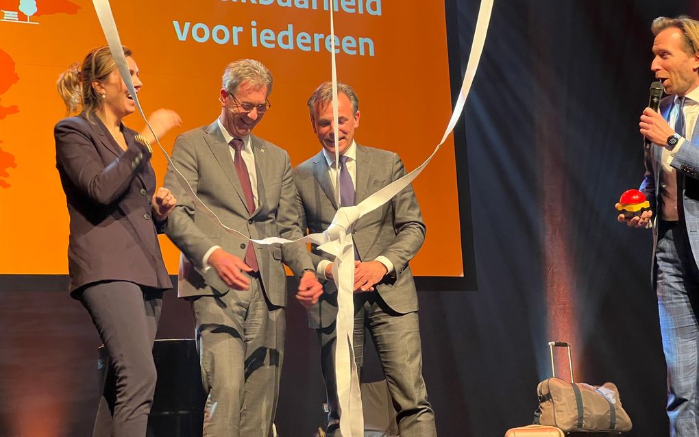 V.l.n.r. staatssecretaris Heijnen van Infrastructuur en Waterstaat, de Zeeuwse gedeputeerde van Mobiliteit Van der Maas en minister Harbers van Infrastructuur en Waterstaat tijdens de symbolische overhandiging van zes miljoen euro van het Rijk voor de eerste pilot innovatief publiek vervoer Zeeland. beeld Ministerie van Infrastructuur en Waterstaat
