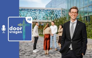 Ds. A.S. Middelkoop met op de achtergrond jongeren die met elkaar in gesprek zijn.