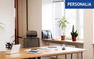 Bureau met een laptop en enkele paperassen, daarachter een lege bureaustoel