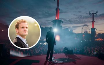 Een jongeman in een pak staat op een podium; duizenden feestende mensen kijken toe, met de handen in de lucht. In de foto staat een portretje van een jongeman met donkere krullen