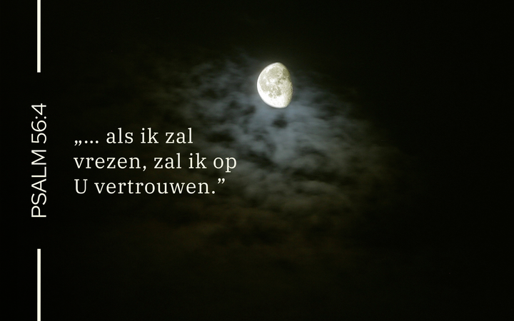 Een donkere nacht; de maan schijnt door de wolken.