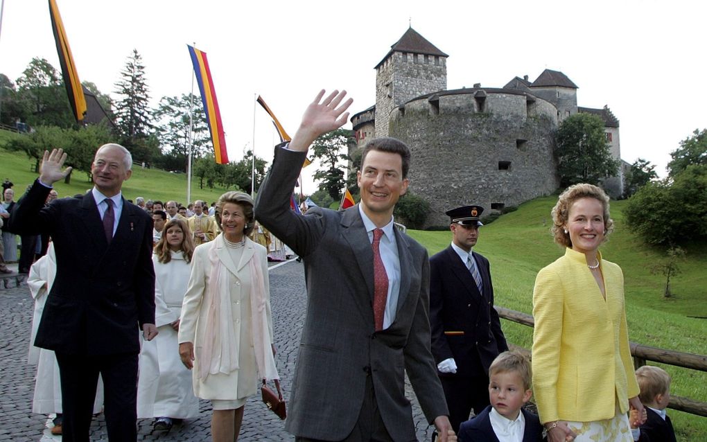 Vorst Hans Adam en zijn vrouw in 2004 bij de overdracht van zijn regeringstaken aan oudste zoon Alois (rechts met zijn gezin). beeld EPA, Arno Balzarini