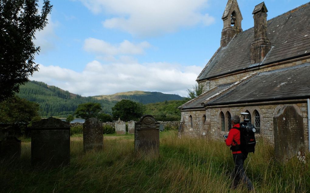 Een wandelaar loopt tussen de graven.
