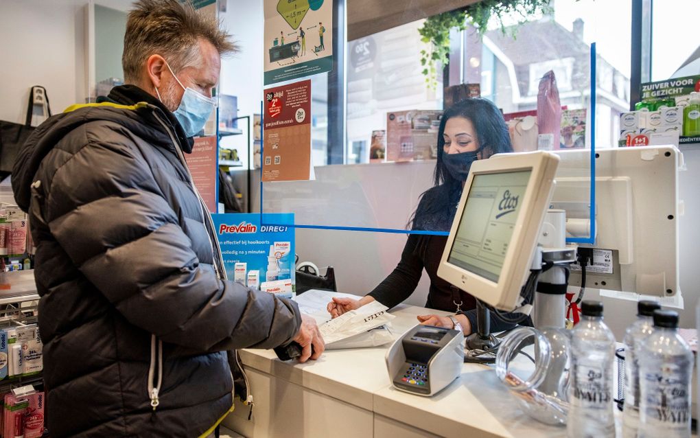 Een klant koopt een coronazelftest bij Etos. beeld ANP, Ramon van Flymen