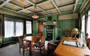 De werkkamer van Anton Kröller. Opvallend zijn de groene geglazuurde bakstenen en de vijfhoekige tafel, een verwijzing naar de vrijmetselarij. beeld uitg. WBooks