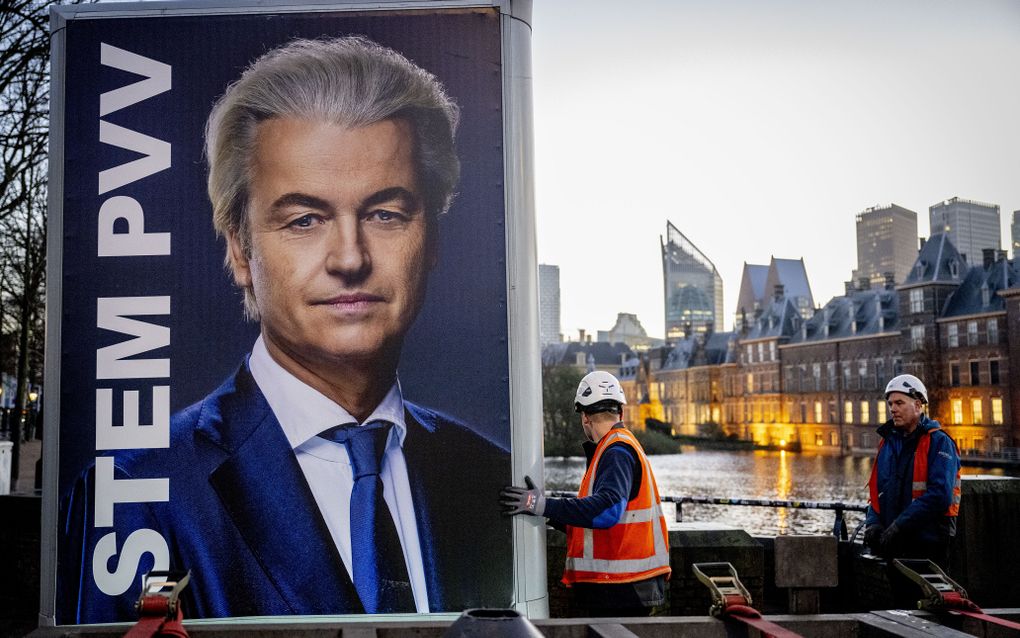 Een verkiezingsbord van PVV-leider Geert Wilders wordt verwijderd bij het Binnenhof, een dag na de Tweede Kamerverkiezingen. beeld ANP, Robin Utrecht