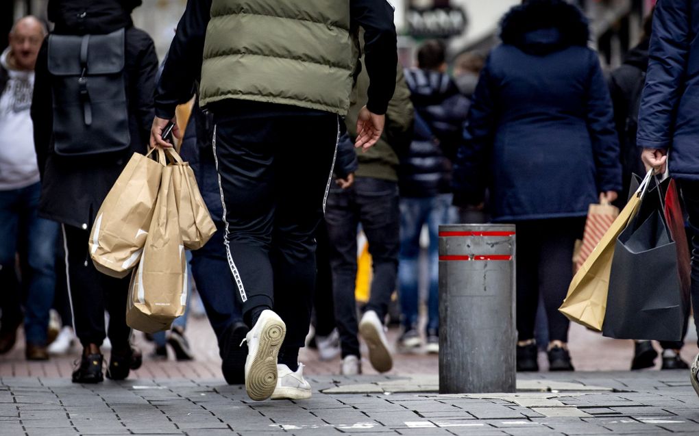 Winkelend publiek op Black Friday. De plastic tas is duidelijk op zijn retour. beeld ANP, Koen van Weel