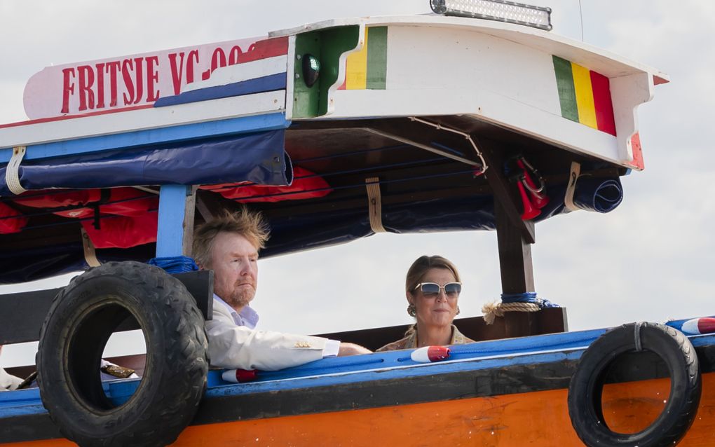 Man met wapperende haren en vrouw met zonnebril in een boot.