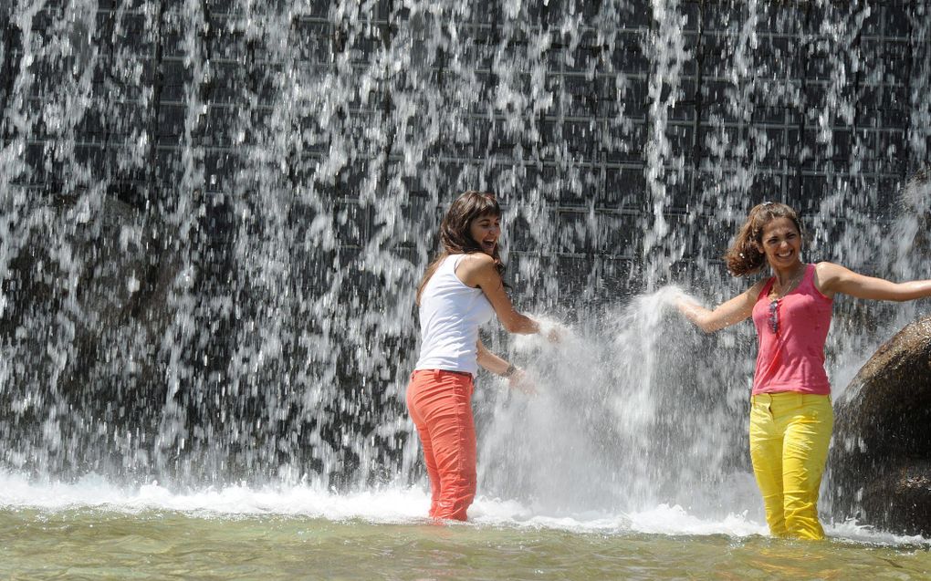 Toeristen zoeken verkoeling in een fontein in Valentino Park in Turijn. Foto EPA