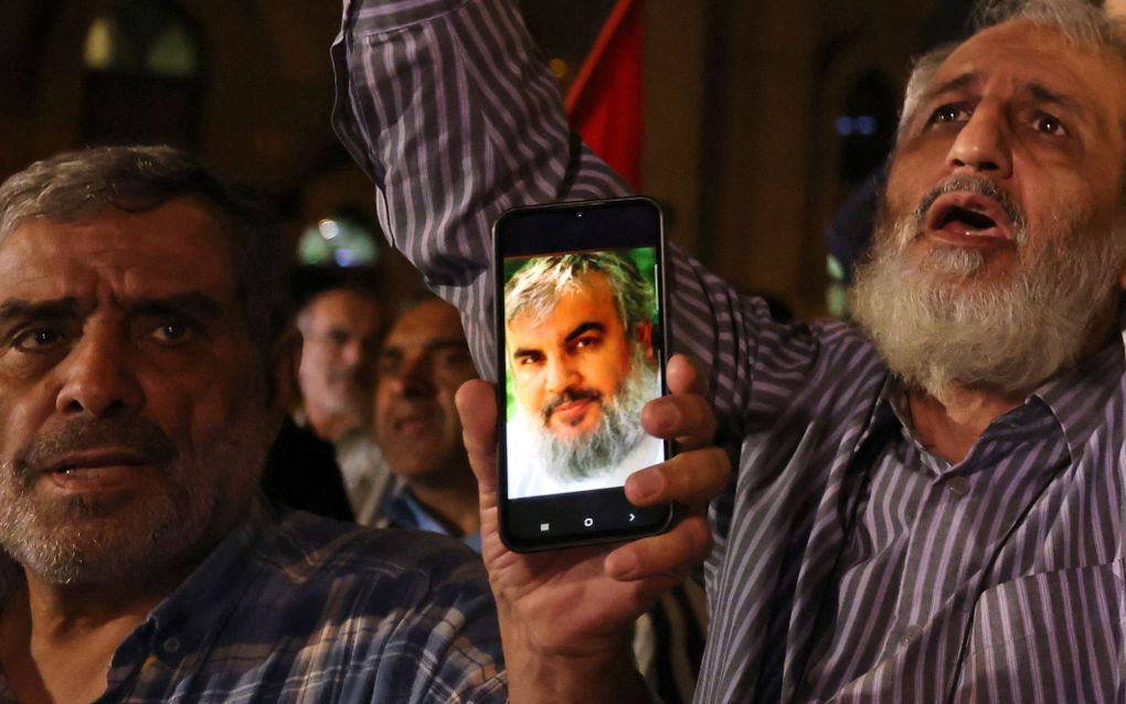 Een man toont een foto van Hassan Nasrallah op zijn smartphone. De secretaris-generaal van de terreurbeweging Hezbollah is volgens Israël om het leven gekomen bij een Israëlische aanval, vrijdag. beeld AFP, Atta Kenare