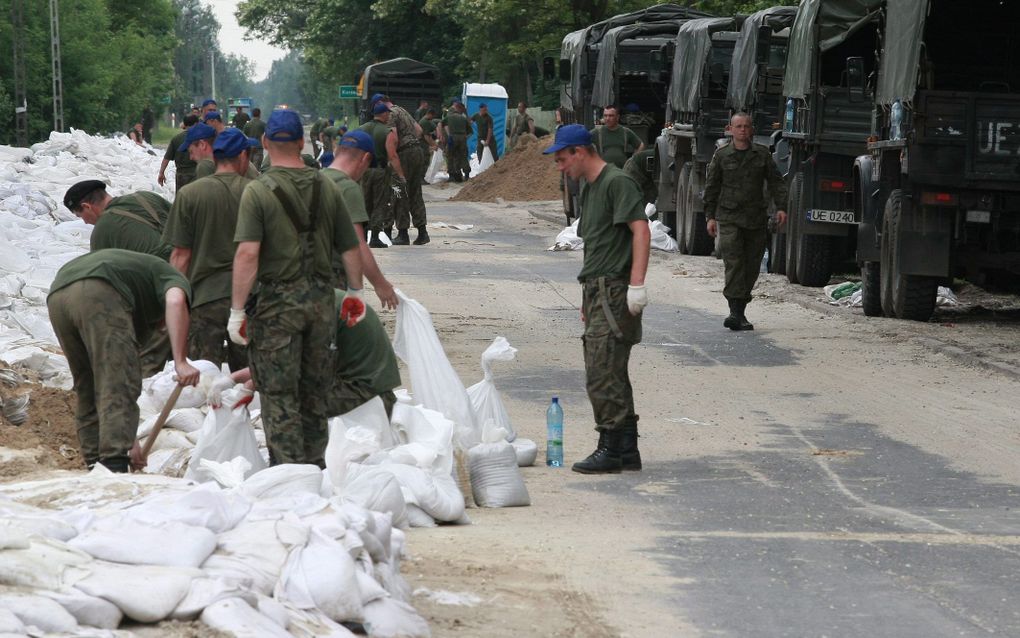 Pools militairen verzwaren een dijk. Foto EPA