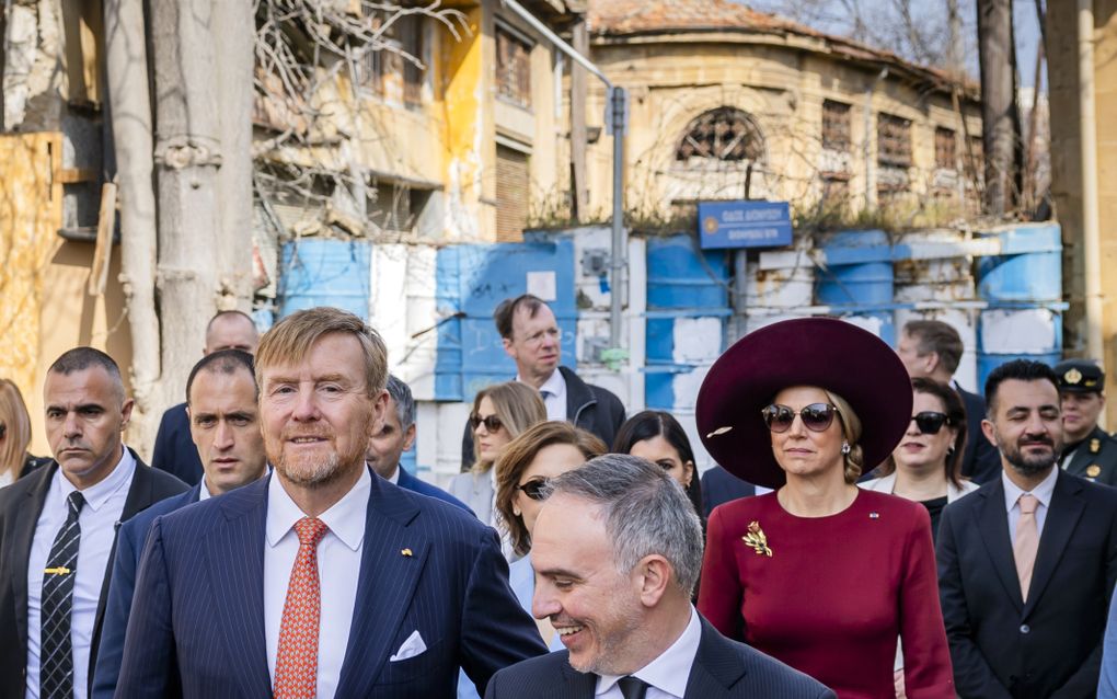 Het koningspaar met de burgemeester van Nicosia. Op de achtergrond de wegversperring aan de rand van de bufferzone. beeld ANP, Remko de Waal