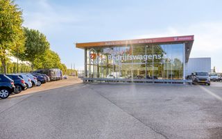 Parkeerplaats met auto’s naast de showroom van een autogarage