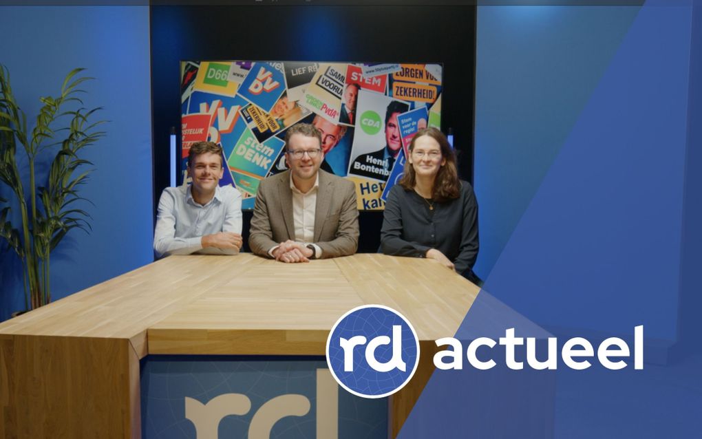 Drie redacteuren achter tafel. 