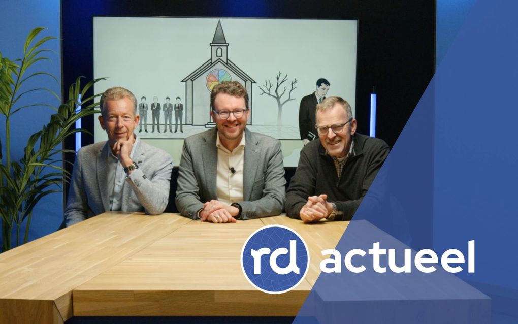 Drie vriendelijk lachende mannen zitten aan een houten tafel.