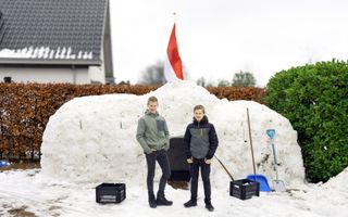Twee jongens staan voor een grote iglo.