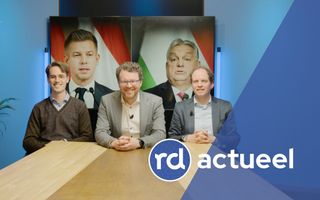 Drie redacteuren achter tafel. 