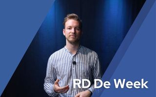 Man met gestreept overhemd kijkt vriendelijk de camera in.