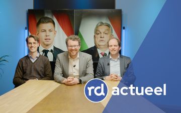 Drie redacteuren achter tafel. 