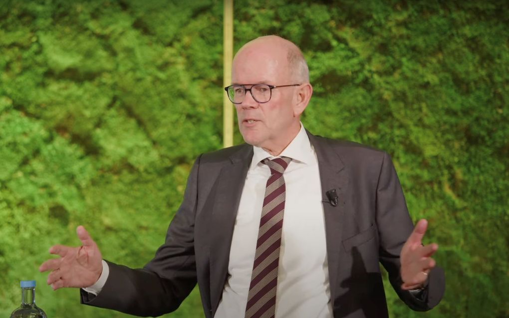 Een man met kalend hoofd in pak met stropdas.