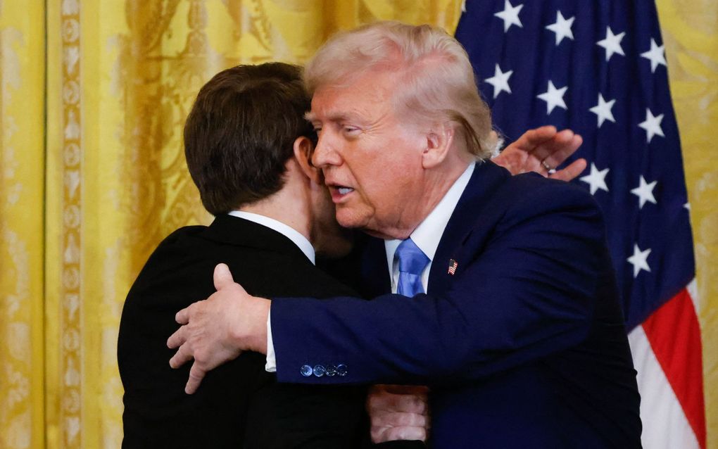 De Franse president Emmanuel Macron (l.) en zijn Amerikaanse ambtgenoot Donald Trump omhelzen elkaar na een gezamenlijke persconferentie in het Witte Huis. beeld AFP, Ludovic Marin