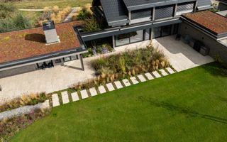 Bovenaanzicht van een tuin met gazon, terras en beplanting