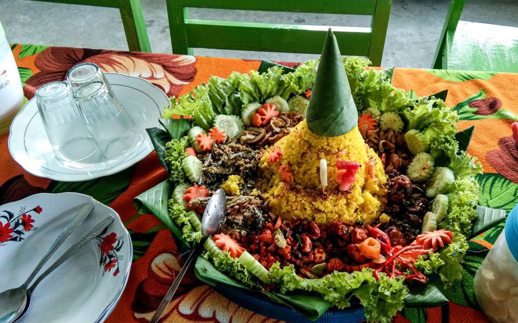 In de manier waarop nasi kuning wordt gepresenteerd, schuilt symboliek. Volgens kenners zou de kegelvorm aan de bovenkant naar God verwijzen. beeld Getty Images